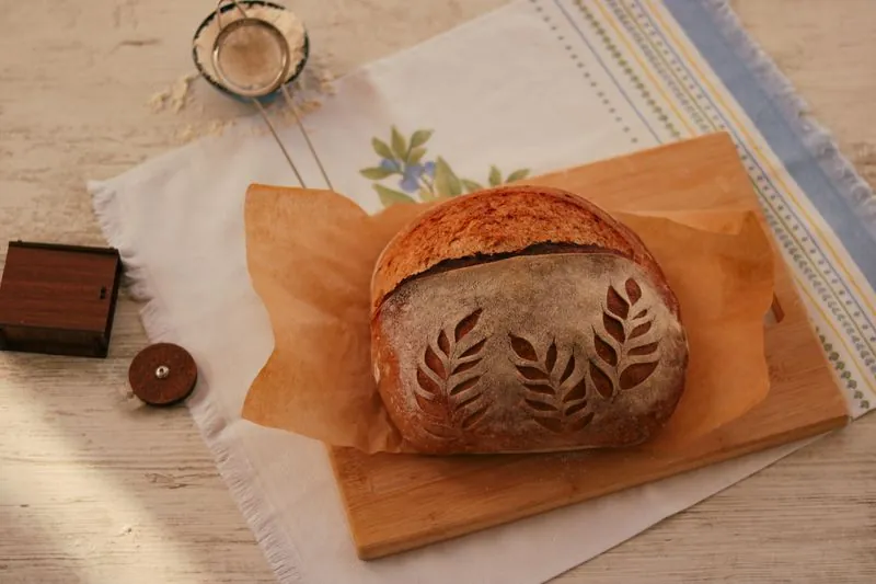 A loaf decorated with a leaf pattern on paper